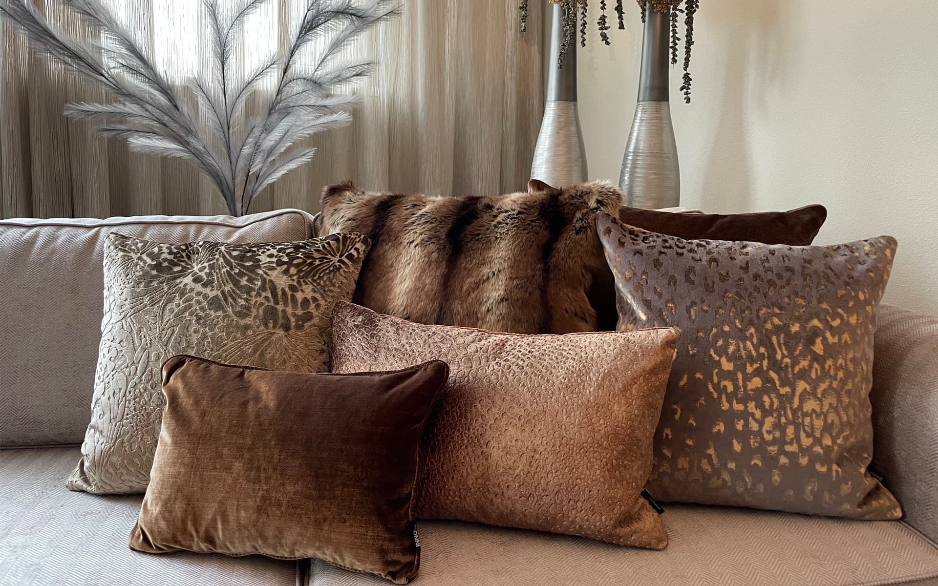 Bruin met gouden luxe sierkussens op lichte bank