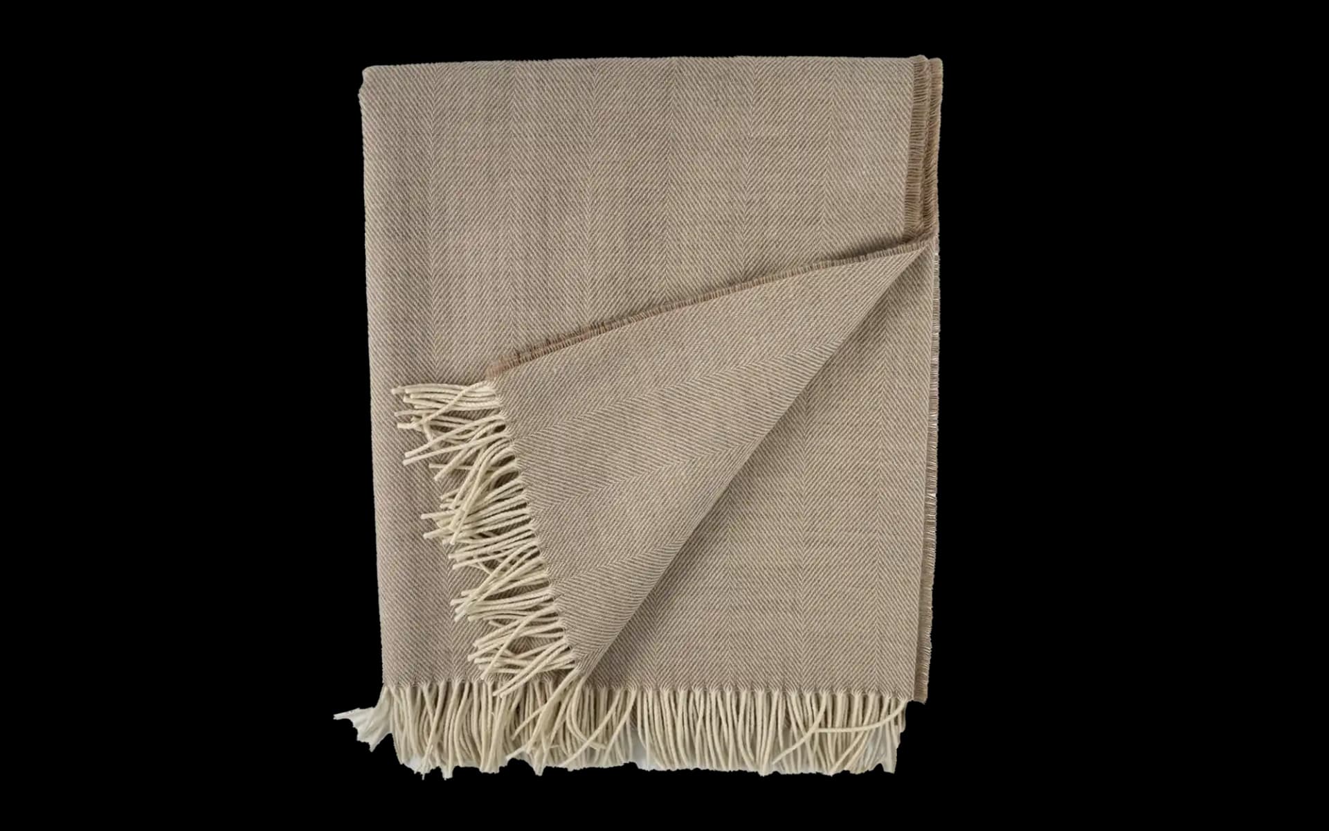 Opengeklapte merino plaid in warme bruine tint, detail zichtbare textuur.